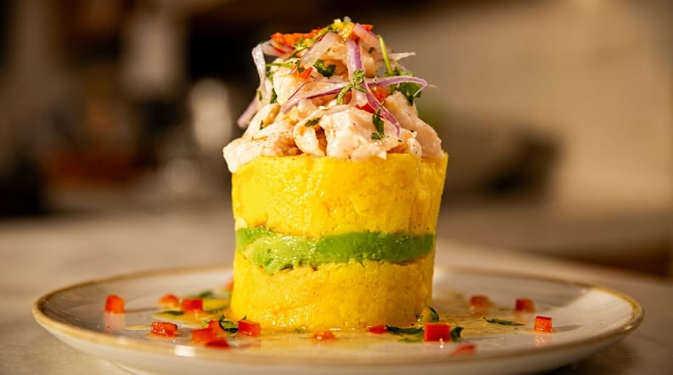 Peruvian causa, a yellow potato terrine layered with green avocado and topped with ceviche.